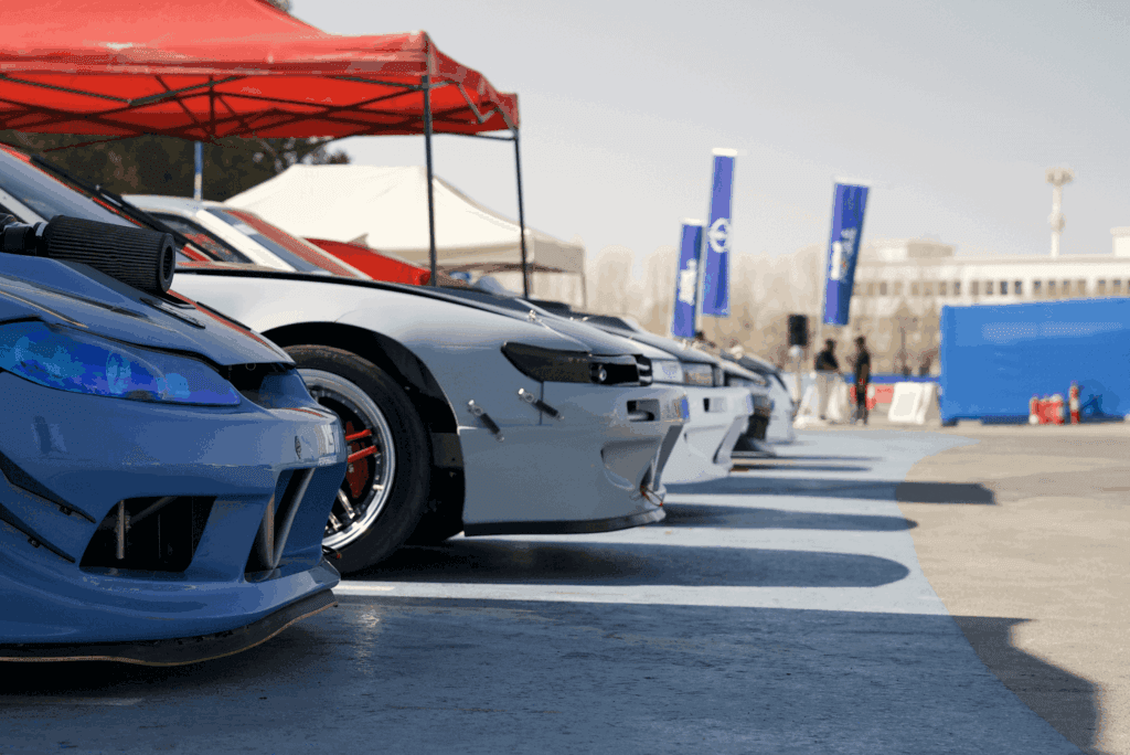 A lineup of modified race cars in various colors at a track, showcasing image.