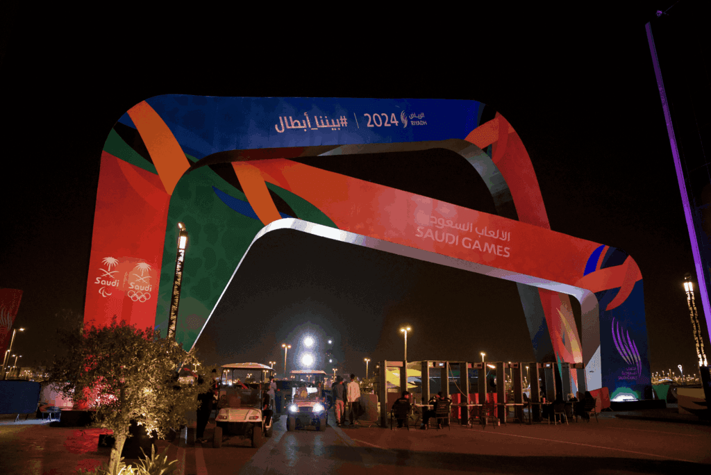 A vibrant archway for the Saudi Games 2024 illuminated at night, showcasing image.