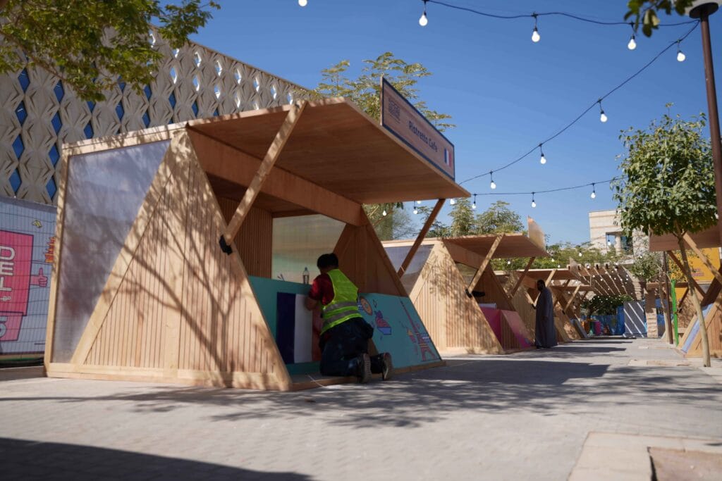 Person decorating outdoor market stalls.