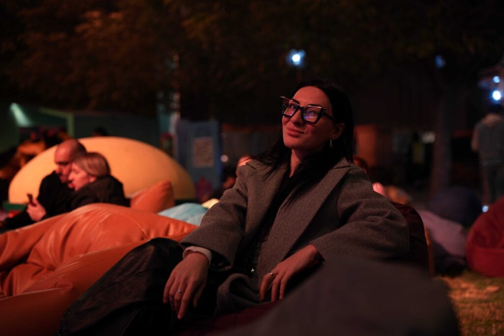 Woman in coat at night.