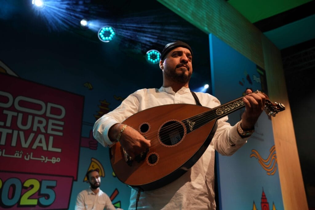 Man playing oud at festival.