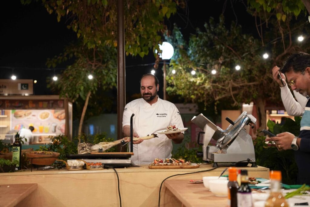 Chef preparing food outdoors.