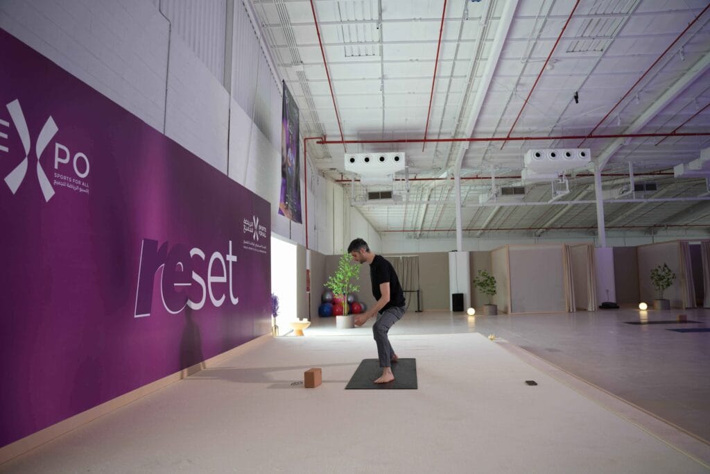 Man doing yoga in large space.