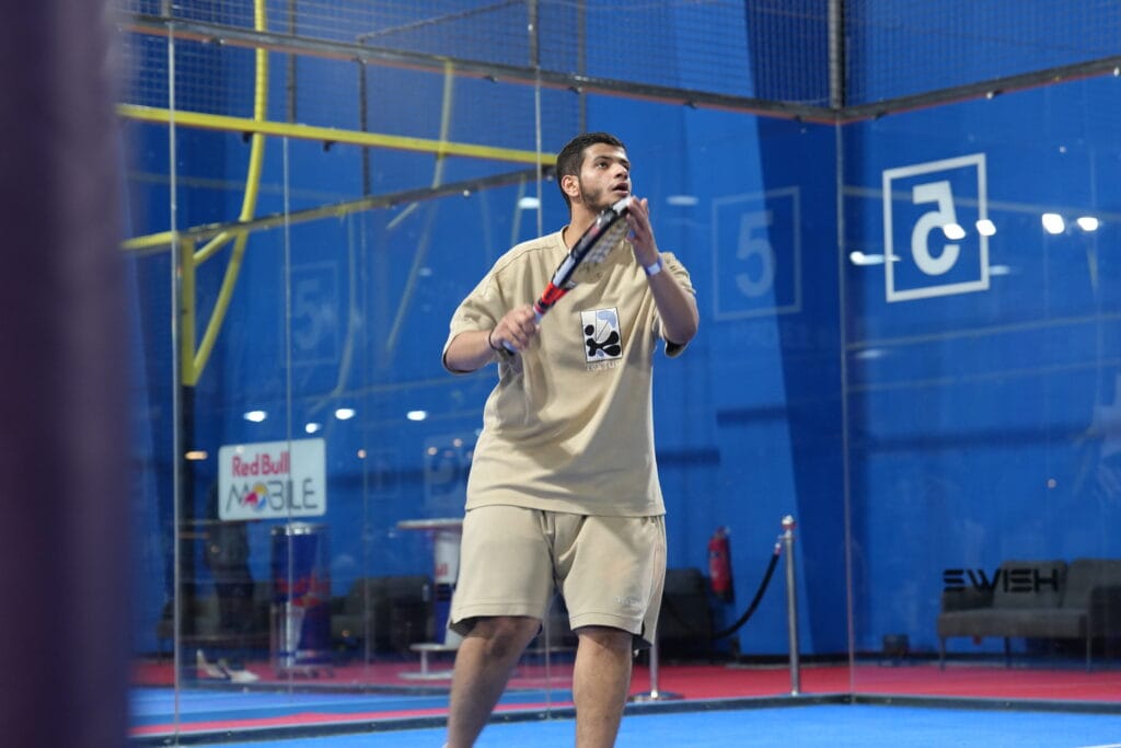 Man playing padel indoors.