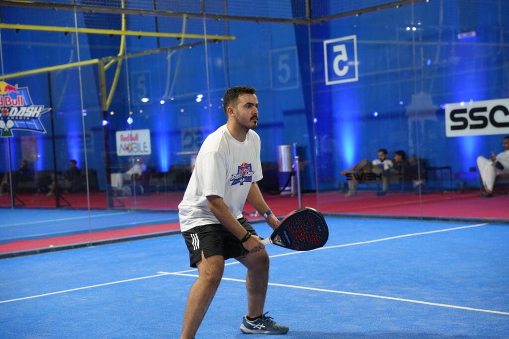 Man playing padel indoors.