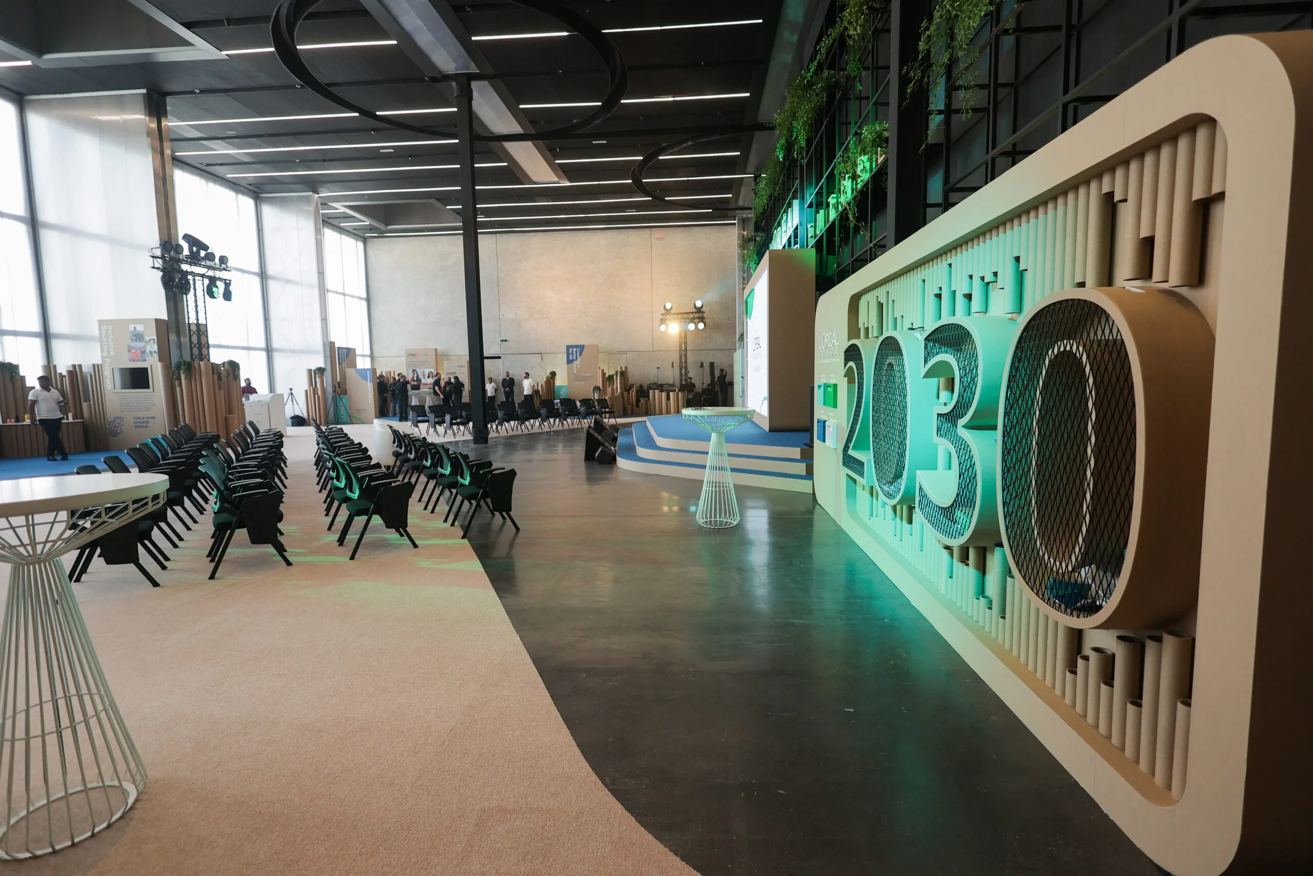 A modern event space featuring rows of black chairs, a stylish table, and a prominent 2030 display, showcasing image.