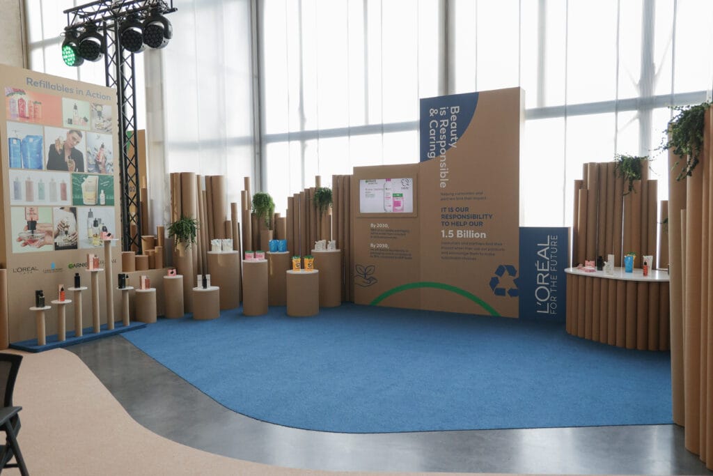 A display showcasing L'Oreal refillable products in a modern setting, emphasizing sustainability and beauty image.