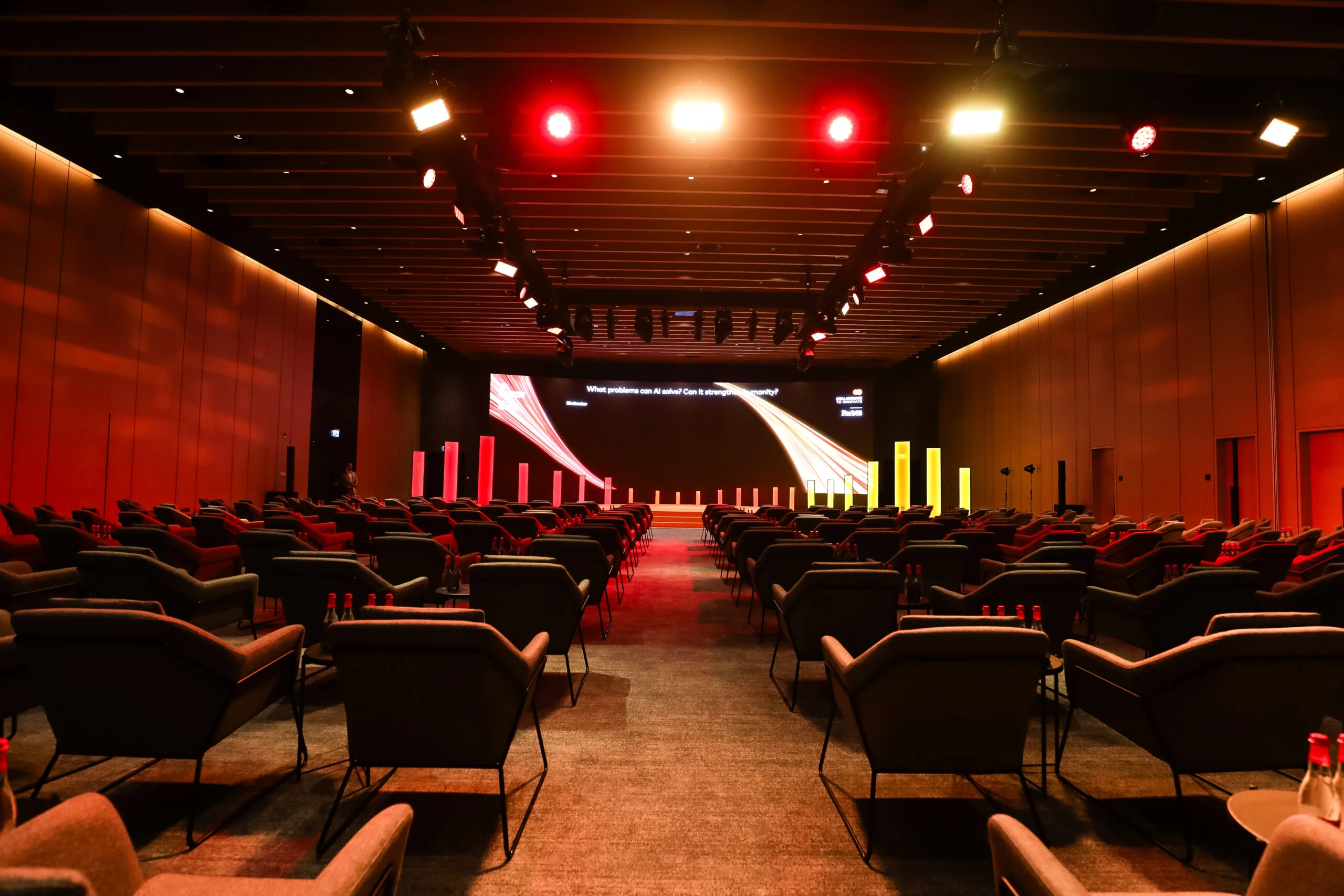 A conference room with red lighting and a seating arrangement of modern chairs, showcasing image.
