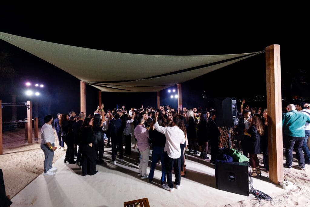 Nighttime beach party under tent.